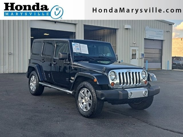 2013 Jeep Wrangler Unlimited Sahara in Black Clearcoat — front three-quarter view